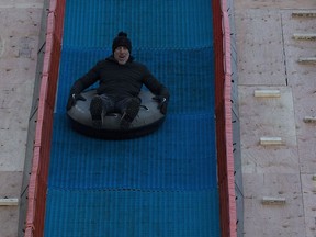 Former CFL and NFL quarterback Jeff Garcia tries out the tube slide at the Grey Cup Festival site on Tuesday, Nov. 20, 2018, in Edmonton.