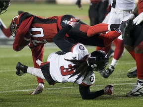 Calgary Stampeders Bakari Grant (20) is tackled by Ottawa Redblacks Rico Murray (3) during the 106th Grey Cup game on Sunday, Nov. 25, 2018, in Edmonton.