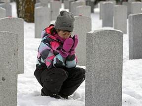 Alexandra White (8-years-old), a grade three student from St. John Bosco School, says a prayer before placing a poppy on a headstone at the No Stone Left Alone ceremony held at Beechmount Cemetery in Edmonton on Monday November 5, 2018. Poppies were placed on all of the headstones in the Cemetery’s Field of Honour by military members and local Edmonton students. (PHOTO BY LARRY WONG/POSTMEDIA)