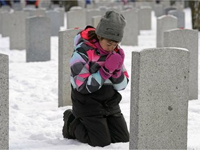 Alexandra White, 8, a Grade-three student from St. John Bosco School, says a prayer before placing a poppy on a headstone at the No Stone Left Alone ceremony held at Beechmount Cemetery in Edmonton on Monday, Nov. 5, 2018. Poppies were placed on all of the headstones in the Cemetery's Field of Honour by military members and local Edmonton students.