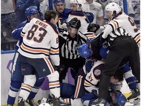 Officials work to separate Tampa Bay Lightning and Edmonton Oilers players during a fight in the third period of an NHL hockey game Tuesday, Nov. 6, 2018, in Tampa, Fla.