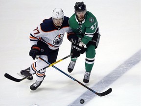 Edmonton Oilers defenceman Oscar Klefbom, left, and Dallas Stars winger Alexander Radulov fight for the puck during NHL action on Jan. 6, 2018.