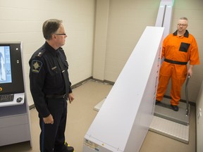 An Edmonton Remand Official demonstrates a scanner designed to reduce the amount of contraband entering the facility. A judge this week recommended random screening for remand centre employees following a report on two 2016 overdose deaths.