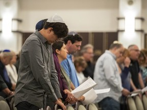 Members of B'nai Aviv Synagogue pray along with Rabbi Adam Watstein in Weston, Fla., Sunday, Oct. 28, 2018, after Saturday's shooting that took place during worship services inside Tree of Life Synagogue in Pennsylvania.