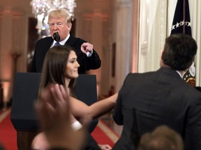 As President Donald Trump points to CNN's Jim Acosta, a White House aide takes the microphone from him during a news conference in the East Room of the White House, Wednesday, Nov. 7, 2018, in Washington.