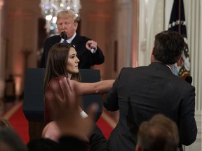President Donald Trump looks on as a White House aide takes away a microphone from CNN journalist Jim Acosta during a news conference in the East Room of the White House, Wednesday, Nov. 7, 2018, in Washington.