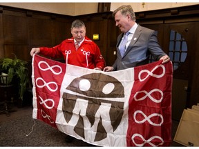 Métis Settlements General Council president Gerald Cunningham presents Indigenous Relations Minister Richard Feehan with a Métis Settlements General Council flag during a celebration of the 80th anniversary of the Métis  Population Betterment Act at the Alberta legislature in Edmonton on Monday, Dec. 3, 2018. Alberta is home to the largest Métis  population in Canada, with 114,000 Métis  people living in the province.