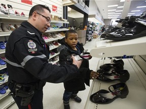 Joseph Ugwu, 7, shops for shoes for his little sister with Const. Chapman Lee during the CopShop event at Londonderry Mall, in Edmonton, on Wednesday Dec. 5, 2018.