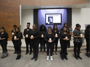 Students hold candles and take part in a moment of silence during a National Day of Remembrance and Action on Violence Against Women ceremony at NorQuest College, in Edmonton Thursday Dec. 6, 2018. Twenty-nine years ago on December 6, 1989, 14 women were murdered at l'Ecole Polytechnique de Montreal.