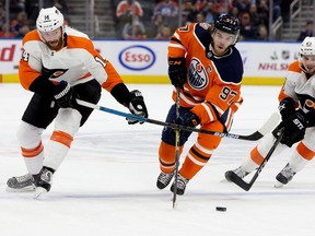 The Edmonton Oilers' Connor McDavid (97) splits the Philadelphia Flyers' Sean Couturier (14) and Scott Laughton (21) during first period NHL action at Rogers Place, in Edmonton Friday Dec. 14, 2018. Photo by David Bloom