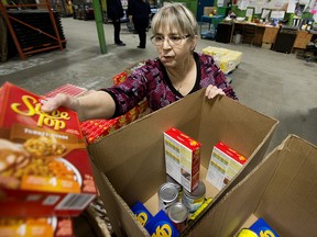 Volunteer Dolores Andreoli packs a food hamper at the Edmonton Food Bank, 11508 120 St., in Edmonton Saturday Dec. 22, 2018. Photo by David Bloom