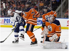 Edmonton Oilers' goaltender Mikko Koskinen (19) makes a save as Darnell Nurse (25) battles the Tampa Bay Lightning' Tyler Johnson (9) during second period NHL action at Rogers Place, in Edmonton Saturday Dec. 22, 2018.