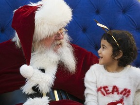 Amira Elsirri, 4, visits with Santa Claus at Bonnie Doon Mall, in Edmonton Sunday Dec. 23, 2018. Photo by David Bloom