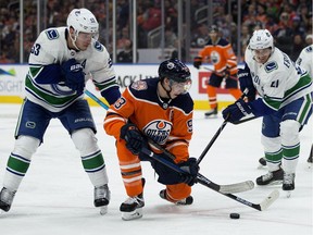 The Edmonton Oilers' Ryan Nugent-Hopkins (93) battles the Vancouver Canucks' Bo Horvat (53) and Loui Eriksson (21) during second period NHL action at Rogers Place, in Edmonton Thursday Dec. 27, 2018.