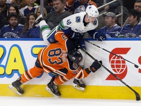 The Edmonton Oilers' Matthew Benning (83) collides with the Vancouver Canucks' Elias Pettersson (40) during third period NHL action at Rogers Place, in Edmonton Thursday Dec. 27, 2018. The Canucks won 4-2. Photo by David Bloom