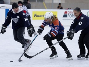 Incoming Edmonton police chief Dale McFee, left, and Edmonton Police Service Sept. Chad Tawfik, right, play hockey with youth in the 10th annual McCauley Cup at the McCauley outdoor skating rink, 10750 96 St. in Edmonton on Friday, Dec. 28, 2018.