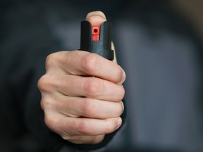 A man holding pepper spray in his hand.