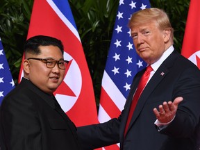 Donald Trump, right, gestures as he meets with North Korea's leader Kim Jong Un at the start of their historic US-North Korea summit, at the Capella Hotel on Sentosa island in Singapore on June 12, 2018.