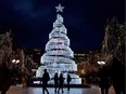 People walk by a Christmas decoration in Athens on December 18, 2018. - t.