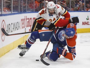 Calgary Flames' Travis Hamonic (24) checks Edmonton Oilers' Leon Draisaitl (29) during second period NHL action in Edmonton on Sunday, Dec. 9, 2018.