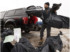 John Paul Janssens (right) and John Marks load gifts on to Janssens truck during the second day of deliveries for 630 CHED's Santas Anonymous in Edmonton, Alberta on Sunday, December 18, 2016. Volunteers through the charitable organization deliver gifts and Christmas cheer to families in need across the city. Ian Kucerak / Postmedia File