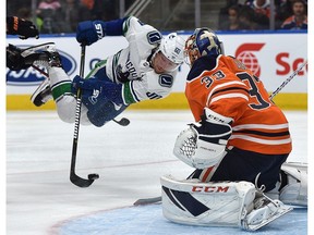 Vancouver Canucks Markus Granlund (60) gets tripped in front of Edmonton Oilers goalie Cam Talbot (33) during NHL pre-season action at Rogers Place in Edmonton, September 25, 2018. Ed Kaiser/Postmedia