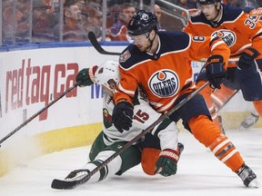 Minnesota Wild's Matt Hendricks (15) is checked by Edmonton Oilers' Adam Larsson (6) during first period NHL action at Rogers Place on Friday December 7, 2018.