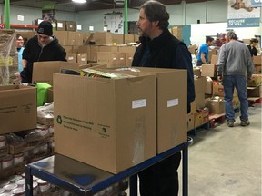 Edmonton's Food Bank volunteers and staff pack boxes in the food bank warehouse on Monday, Dec. 17, 2018. The food bank is short of its goal to reach 350,000 kilograms of food donations and $1.8 million.