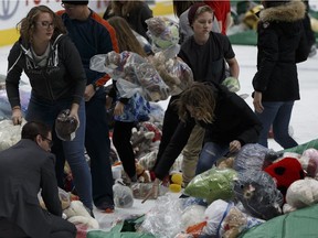 Oil Kings staff, players and 630 CHED Santas Anonymous volunteers collect thousands of donated toys during the 2016 Teddy Bear Toss game between the Edmonton Oil Kings and the Kamloops Blazers at Rogers Place in Edmonton on Dec. 10, 2016.