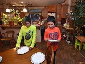 Brothers Will (L), 12, and Wakeen, 11, Gladue helping set the table for their great grandmother, Lillian Whitehead (back) at her home in Little Buffalo. Lubicon Lake Band members participate in a celebration to commemorate the signing of a historic land claim settlement at Little Buffalo, November 13, 2018.