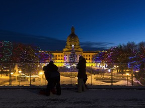 People stop to look at the legislature lights as family-friendly activities include live music, roving performers, games and lantern-making get underway New Year's Eve on Monday, Dec. 31.