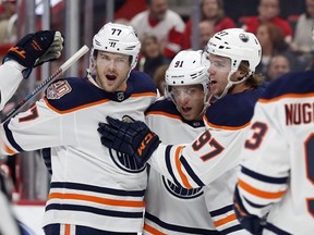 Edmonton Oilers left wing Drake Caggiula (91) is congratulated, after his goal, by teammates defenseman Oscar Klefbom (77), center Connor McDavid (97) and center Ryan Nugent-Hopkins (93) during the first period of an NHL hockey game against the Detroit Red Wings, Saturday, Nov. 3, 2018, in Detroit.