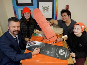 Sherwood Park Next Step High School teacher Kristian Basaraba, front left, and students Kiera Bandura, rear left, Lars Forbes, front right, and Jonah Kinoshita, rear right, with two of the skateboards that they designed to reflect poverty in the city. The school is one of 21 in the Edmonton area to receive a $1,000 grant from United Way Alberta as part of the "Make a Mark on Poverty" program.