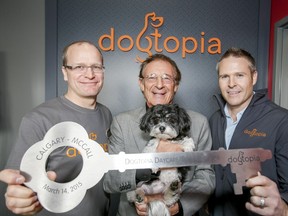 Manager Rob Loskot, left, franchise founder Peter Thomas (with Miss Molly) and Chad Hughes, founder of Hughes Corp., pose for a photo during the grand opening of a Calgary Dogtopia location in 2015.