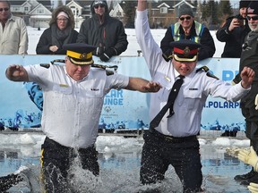 RCMP Criminal Operation Officer John Ferguson (left) and EPS Acting Chief Kevin Brezinski take the plunge in uniform during the annual Polar Plunge fundraiser to support Special Olympics Alberta at Lake Summerside in south Edmonton.