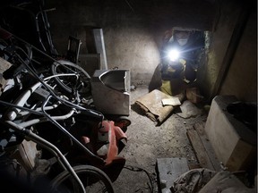 Alex Archbold peers into the cement walled room he discovered in the basement of the home he purchased in north eastern Alberta, Monday Jan. 28, 2019. The only entrance to the room appeared to be a large hole in one of the room's concrete walls.