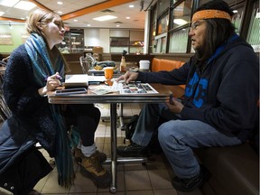 Sarah Schulman, an ethnographer with InWithForward, chats with Johnny Lee in a Whyte Avenue fast food restaurant as she gathers information for the City of Edmonton's Recover Project on Wednesday, Jan. 30, 2019.