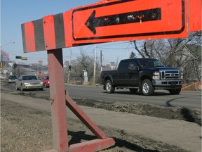 Cars are framed in waiting construction sign.