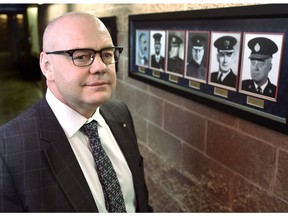 Incoming Edmonton police chief Dale McFee in front of portraits of past police chiefs on display at Edmonton Police Service headquarters in Edmonton.