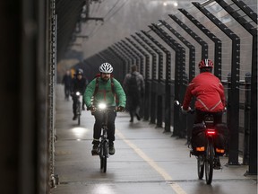 Cyclists and walkers mingle as they commute over the High Level Bridge along the safety barrier in Edmonton, Alberta. File photo.