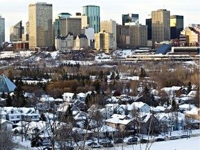 Houses are seen in the shadow of the skyline of Edmonton, Alta. File photo.