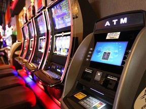 An electronic gambling gaming device is shown next to an ATM bank machine at the grand opening of the Century Downs Casino just north of Calgary on April 1, 2015.