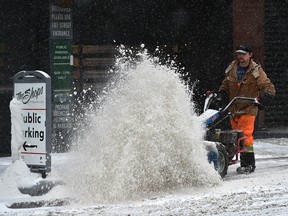 Sweepers tend to the downtown sidewalks as it's forecast the city will received between 5 to 10 cm of snowfall Saturday in Edmonton, December 29, 2018. Ed Kaiser/Postmedia