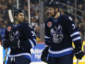Seth Griffith (left) and Logan Shaw of the Manitoba Moose speak during a break before taking to the power play against the Colorado Eagles in Winnipeg on Dec. 30, 2018.
