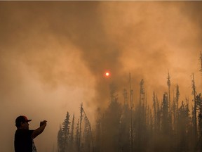Verne Tom photographs a wildfire burning along a logging road approximately 20 km southwest of Fort St. James, B.C., on Wednesday, August 15, 2018. The British Columbia government has declared a provincial state of emergency to support the response to the more than 500 wildfires burning across the province.