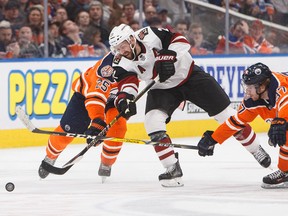 Arizona Coyotes forward Derek Stepan takes a shot as Edmonton Oilers defenceman Darnell Nurse and captain Connor McDavid try to stop him on Jan. 12, 2019, during NHL action in Edmonton.