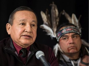 Grand Chief Stewart Phillip, left, president of the Union of B.C. Indian Chiefs, speaks as William George, a member of the Tsleil-Waututh First Nation and a guardian at the watch house near Kinder Morgan's Burnaby facility, listens during a news conference with Indigenous leaders and politicians opposed to the expansion of the Trans Mountain pipeline, in Vancouver, B.C., on Monday April 16, 2018.