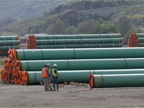 Workmen inspect steel pipe to be used in the oil pipeline construction of the Trans Mountain Expansion Project at a stockpile site in Kamloops, British Columbia, Canada May 29, 2018.