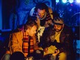 Rodolfo (Adam Fisher), Marcello (Lukas Johan) and Colline (Roland Burks) warm themselves over the fire during Mercury Opera's La Boheme, staged at the Chez Pierre Cabaret through March 9.