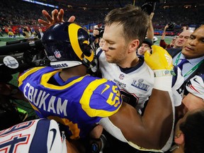 Tom Brady of the New England Patriots hugs Samson Ebukam of the Los Angeles Rams after the Patriots defeat the Rams 13-3 during Super Bowl LIII at Mercedes-Benz Stadium on Sunday, Feb. 3, 2019 in Atlanta, Georgia.
